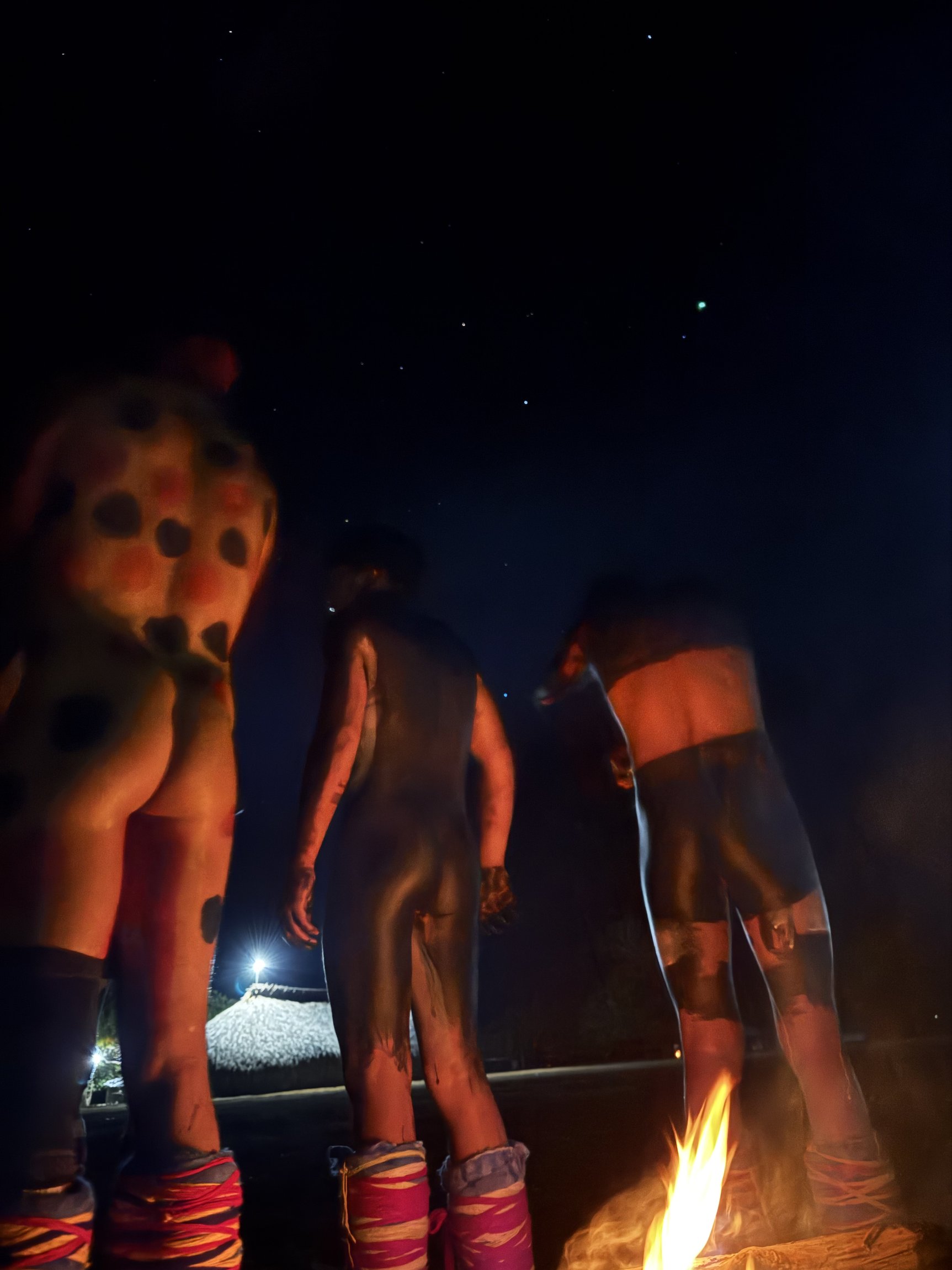 Grupo com pintura corporal ao redor da fogueira