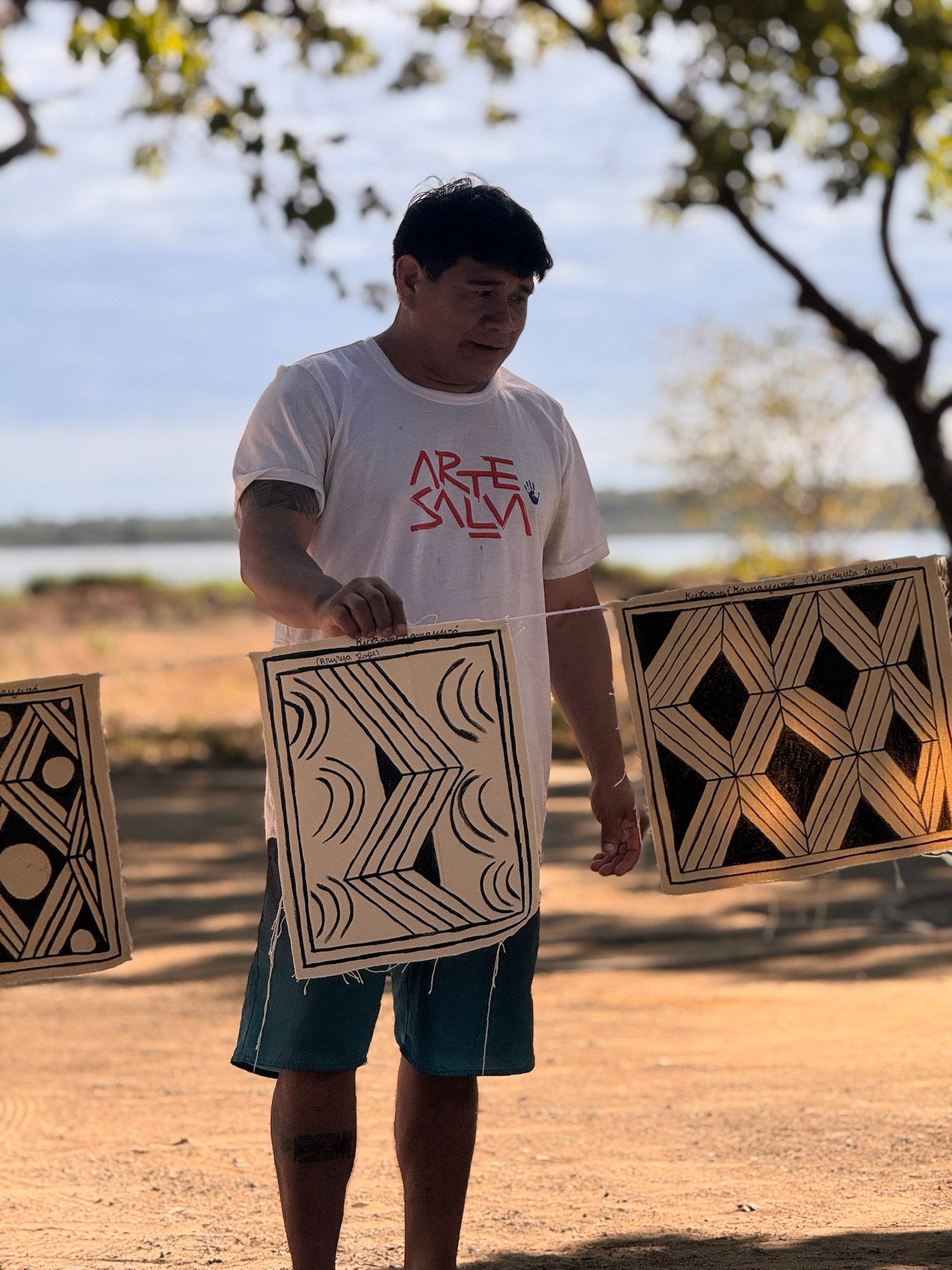 Pessoa segurando painel de grafismo, paisagem ao fundo